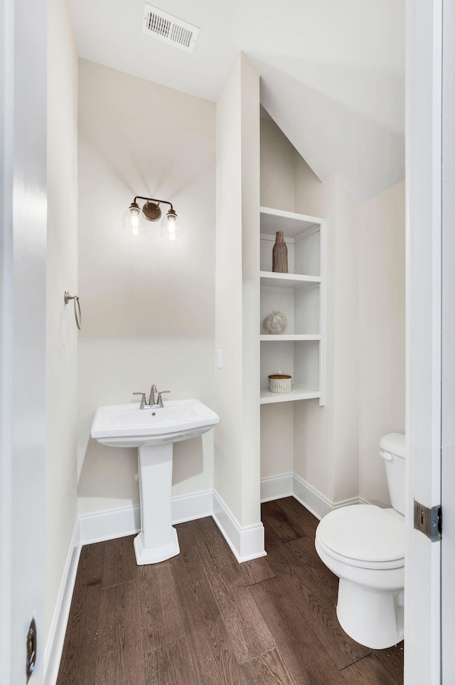 bathroom with wood-type flooring, toilet, and sink