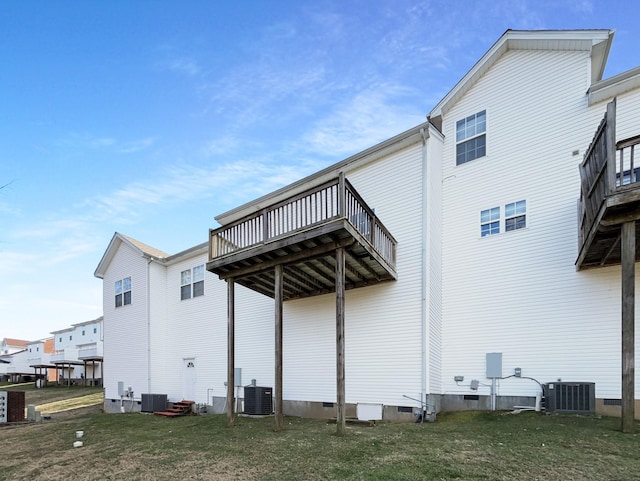 rear view of property with central AC and a lawn