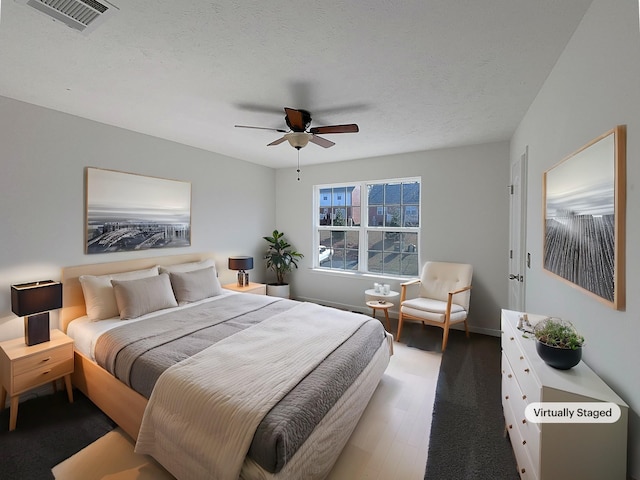 bedroom featuring a textured ceiling, wood-type flooring, and ceiling fan