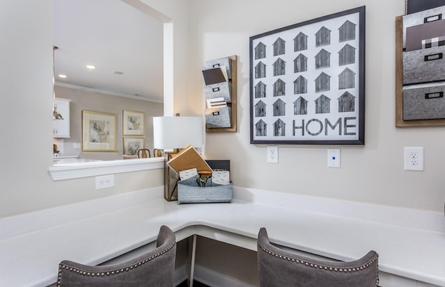 living area with crown molding and built in desk