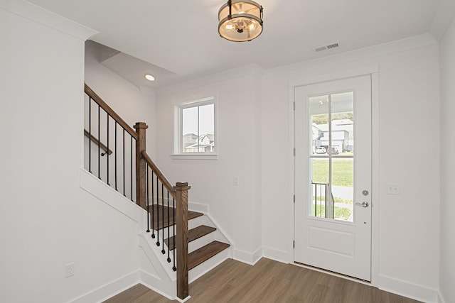 entrance foyer featuring dark wood-type flooring and crown molding