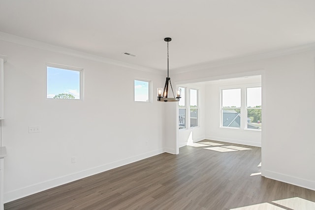 unfurnished dining area with ornamental molding, a chandelier, and hardwood / wood-style floors