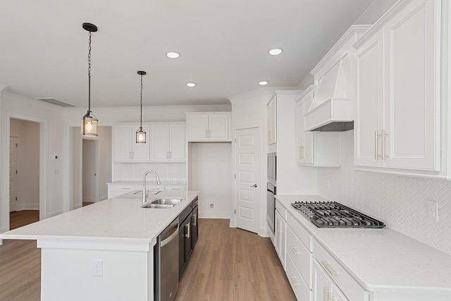 kitchen featuring white cabinetry, stainless steel appliances, sink, and a center island with sink