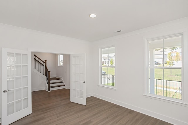 unfurnished room with french doors, plenty of natural light, and dark hardwood / wood-style floors