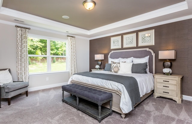 bedroom featuring a raised ceiling, ornamental molding, and carpet flooring