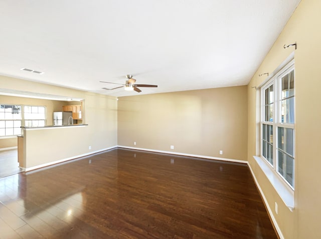 unfurnished living room with dark hardwood / wood-style floors and ceiling fan