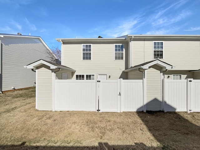 back of house with a lawn