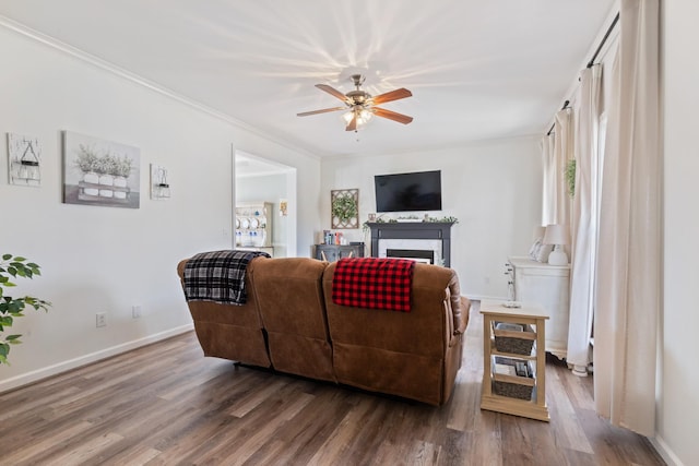 living room featuring crown molding, wood-type flooring, and ceiling fan