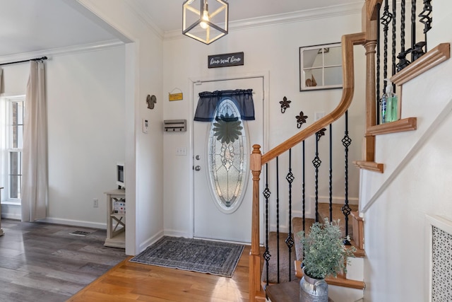 entryway with hardwood / wood-style flooring, ornamental molding, and a healthy amount of sunlight