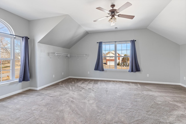 additional living space with a healthy amount of sunlight, lofted ceiling, carpet floors, and ceiling fan