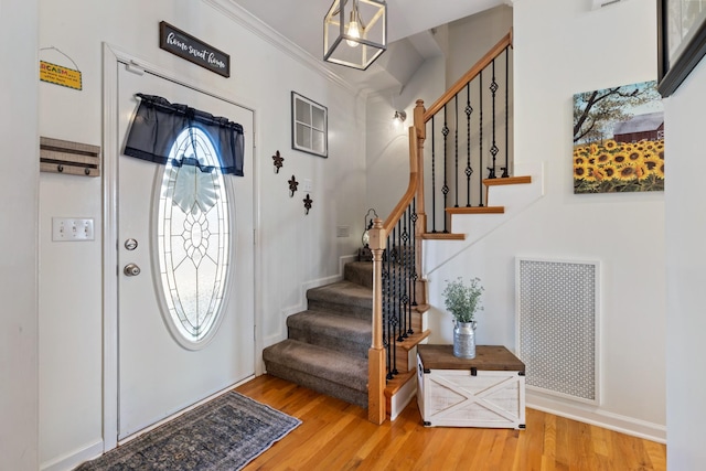 entrance foyer featuring crown molding and wood-type flooring