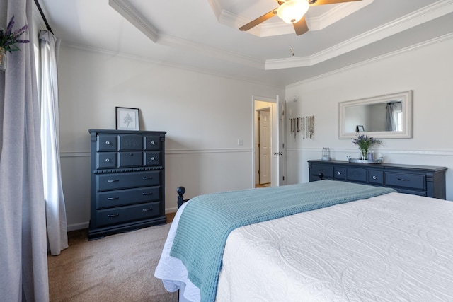 carpeted bedroom with crown molding, a tray ceiling, and ceiling fan