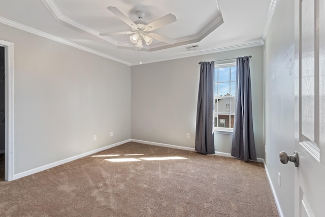 carpeted spare room featuring ornamental molding, ceiling fan, and a tray ceiling