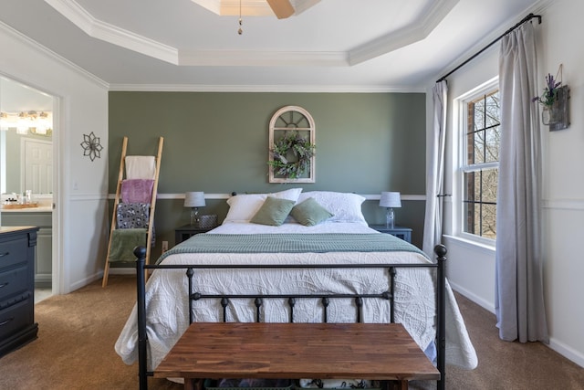 bedroom featuring crown molding, ceiling fan, carpet flooring, ensuite bathroom, and a raised ceiling