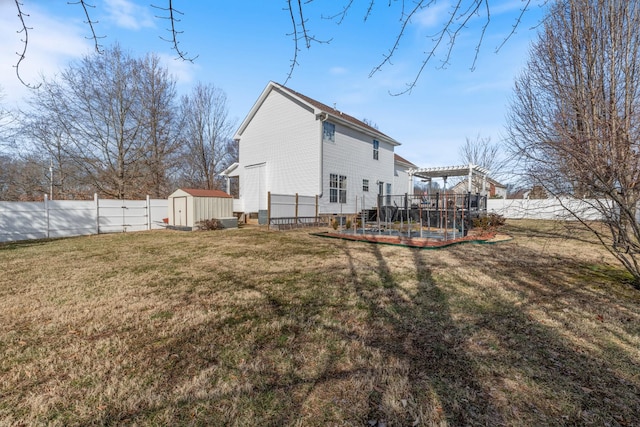 rear view of property with a yard, a pergola, and a shed