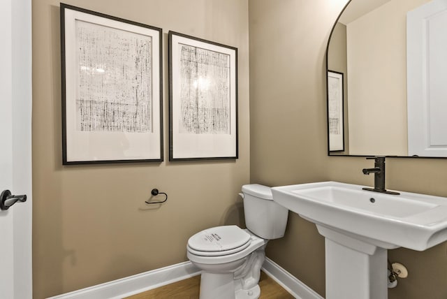 bathroom featuring sink, hardwood / wood-style flooring, and toilet