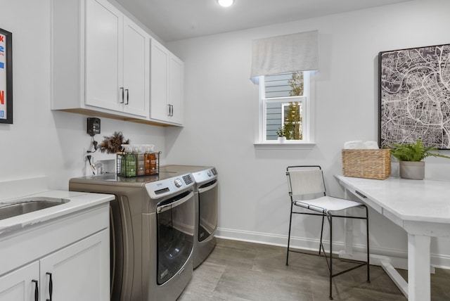 laundry area with cabinets, washer and dryer, and sink