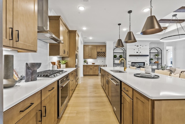 kitchen featuring extractor fan, appliances with stainless steel finishes, sink, hanging light fixtures, and a large island