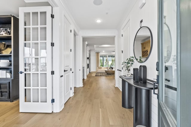 hallway with crown molding and light wood-type flooring