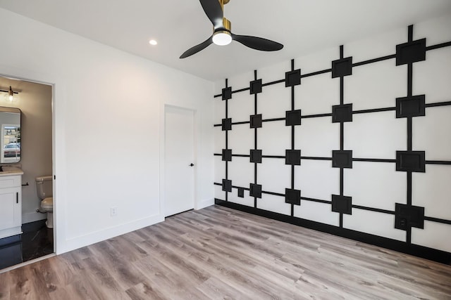 unfurnished bedroom with ceiling fan, ensuite bathroom, and light hardwood / wood-style floors