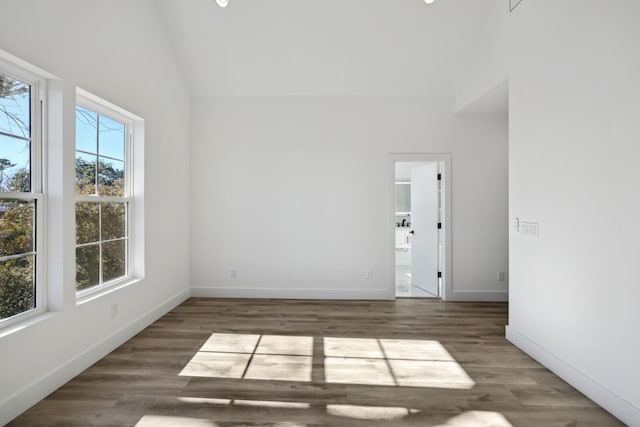 empty room with dark wood-type flooring and vaulted ceiling