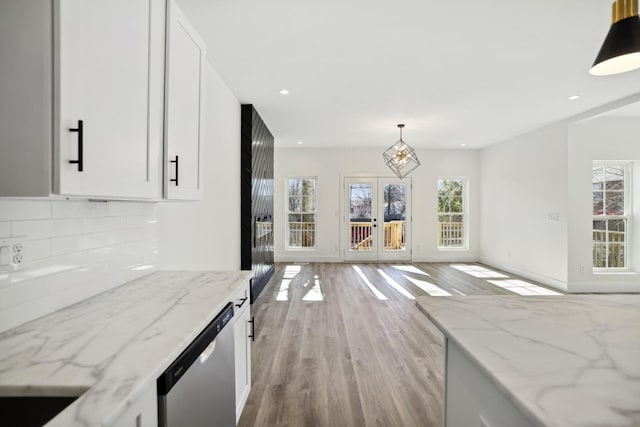 kitchen featuring light stone countertops, white cabinets, and decorative light fixtures