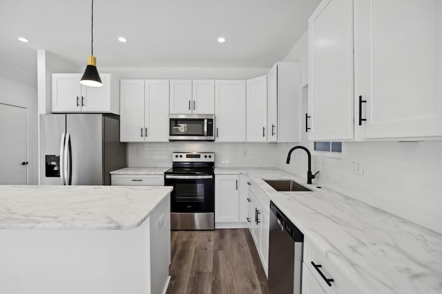 kitchen featuring sink, appliances with stainless steel finishes, white cabinetry, backsplash, and light stone counters