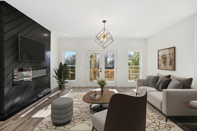 living room featuring french doors, a wealth of natural light, and light hardwood / wood-style flooring