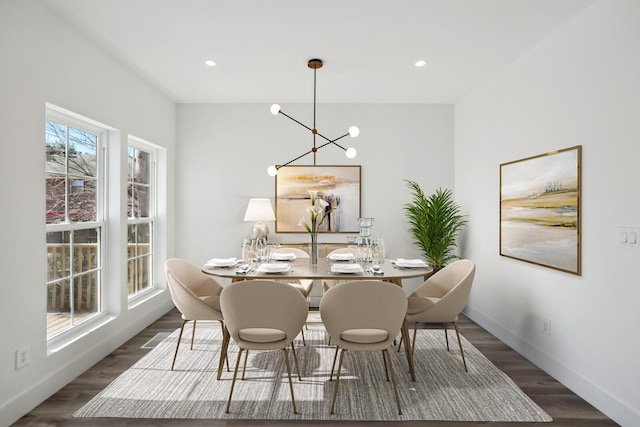 dining area with dark wood-type flooring and a chandelier