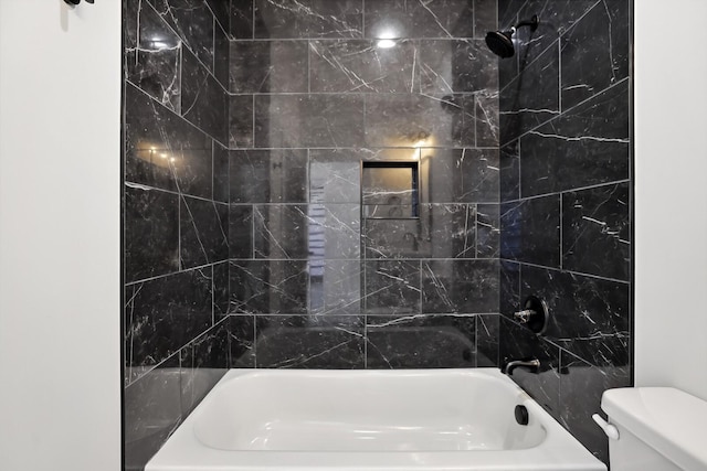 bathroom with tiled shower / bath combo and toilet