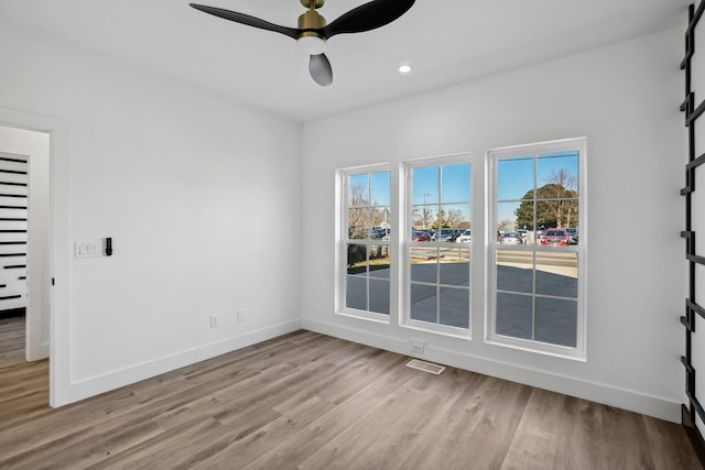 spare room with ceiling fan and light wood-type flooring