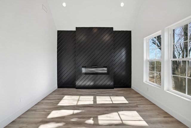 empty room featuring vaulted ceiling and light wood-type flooring