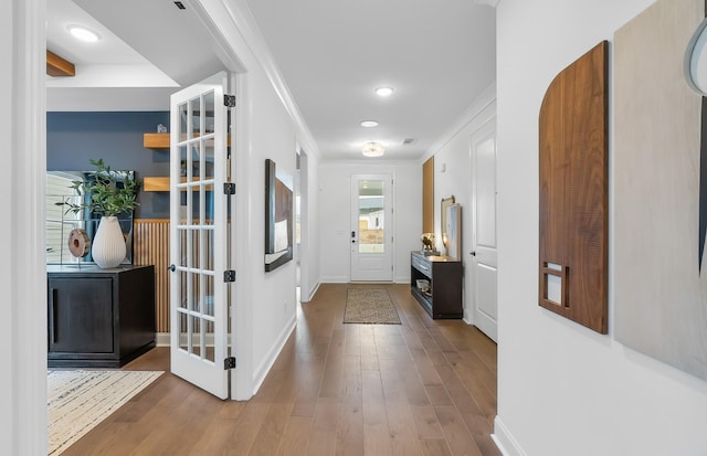 entryway with hardwood / wood-style flooring and ornamental molding