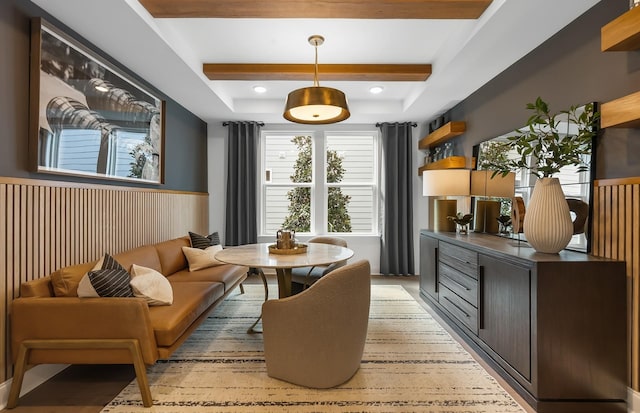 interior space with breakfast area, wooden walls, and a raised ceiling