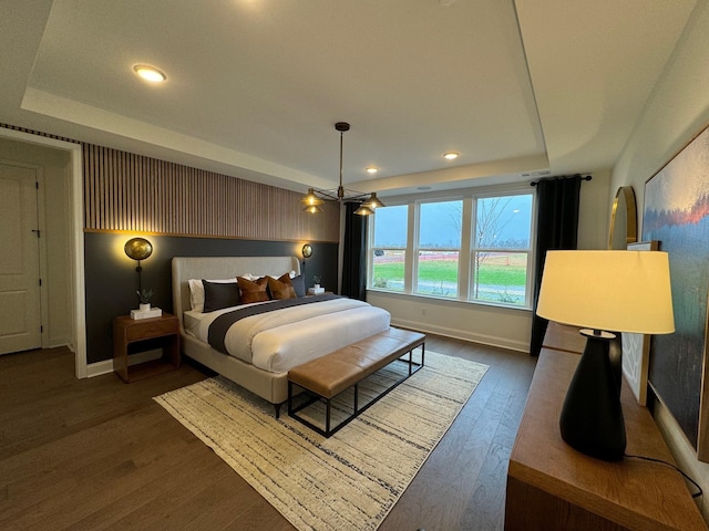 bedroom featuring dark hardwood / wood-style floors and a tray ceiling