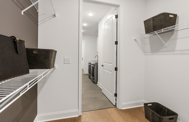 spacious closet featuring washer / clothes dryer and light hardwood / wood-style floors