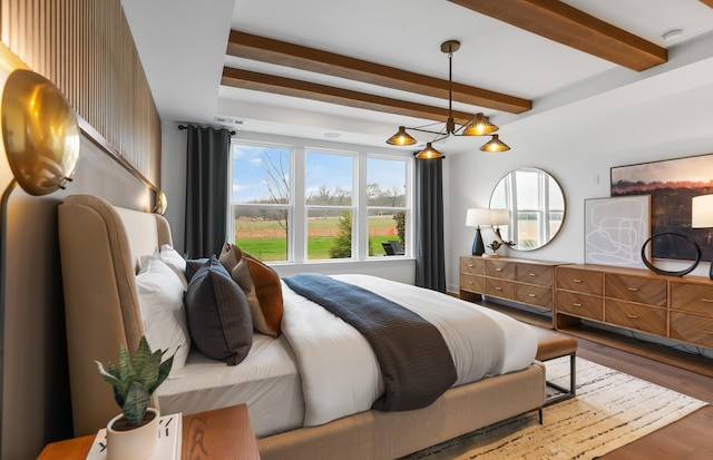 bedroom with an inviting chandelier, beam ceiling, and wood-type flooring