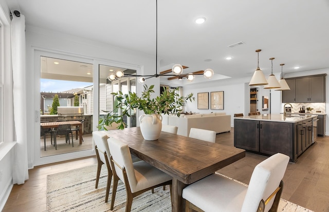 dining area featuring ceiling fan, sink, and hardwood / wood-style floors