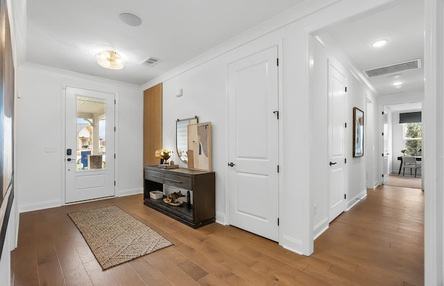 entryway with crown molding and wood-type flooring