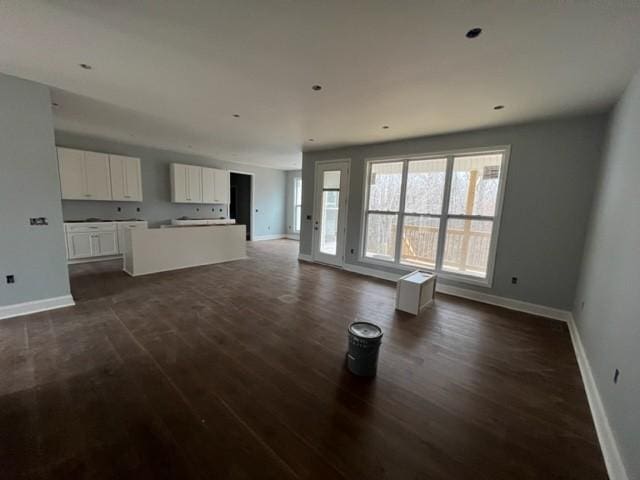 unfurnished living room with dark wood-type flooring