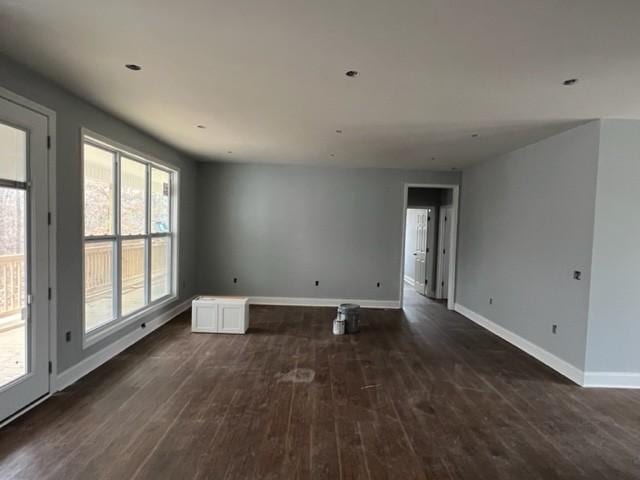 spare room with dark wood-type flooring and a wealth of natural light