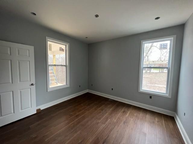 spare room featuring dark wood-type flooring