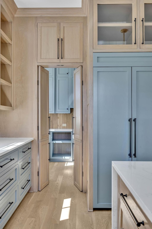 kitchen with light stone countertops, light brown cabinetry, and light wood-type flooring