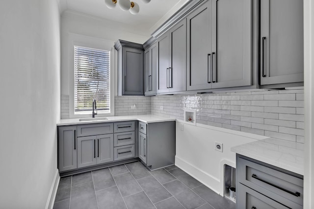 clothes washing area featuring sink, dark tile patterned flooring, cabinets, hookup for a washing machine, and electric dryer hookup