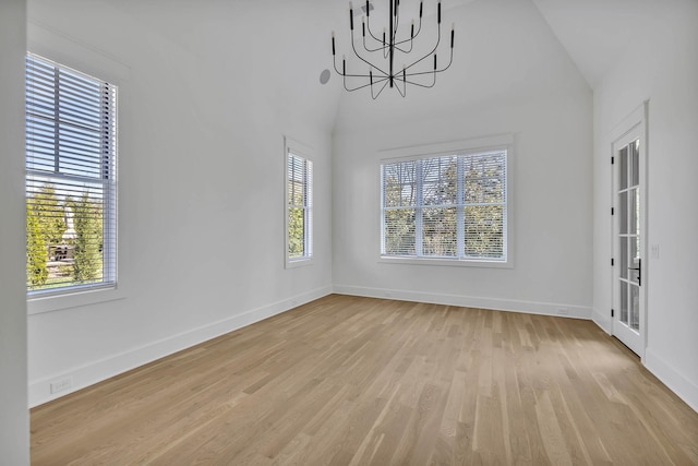 unfurnished dining area featuring a healthy amount of sunlight, a chandelier, and light hardwood / wood-style floors