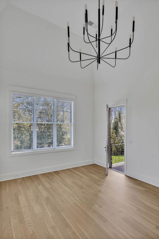 interior space with lofted ceiling, a chandelier, and light wood-type flooring