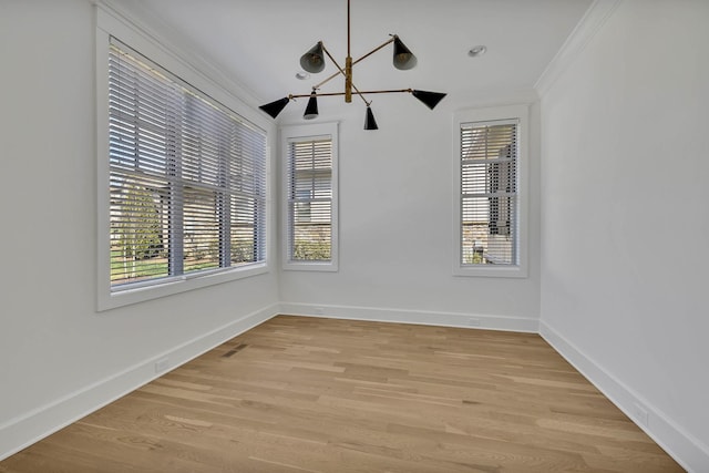 spare room with ornamental molding and light wood-type flooring