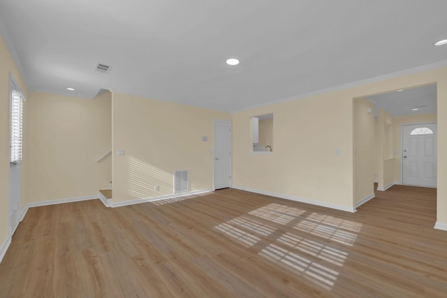 spare room with crown molding and light hardwood / wood-style flooring