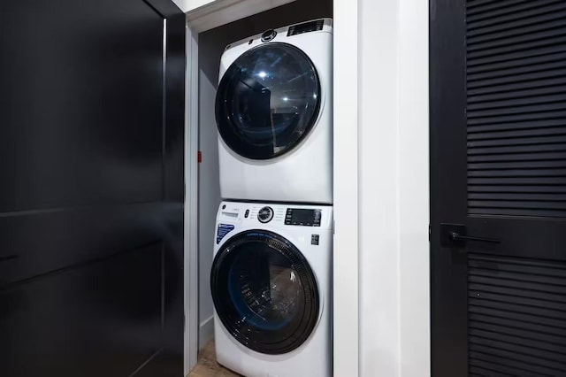 clothes washing area with stacked washer / dryer