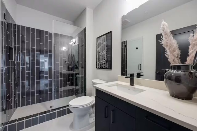 bathroom with vanity, an enclosed shower, and toilet